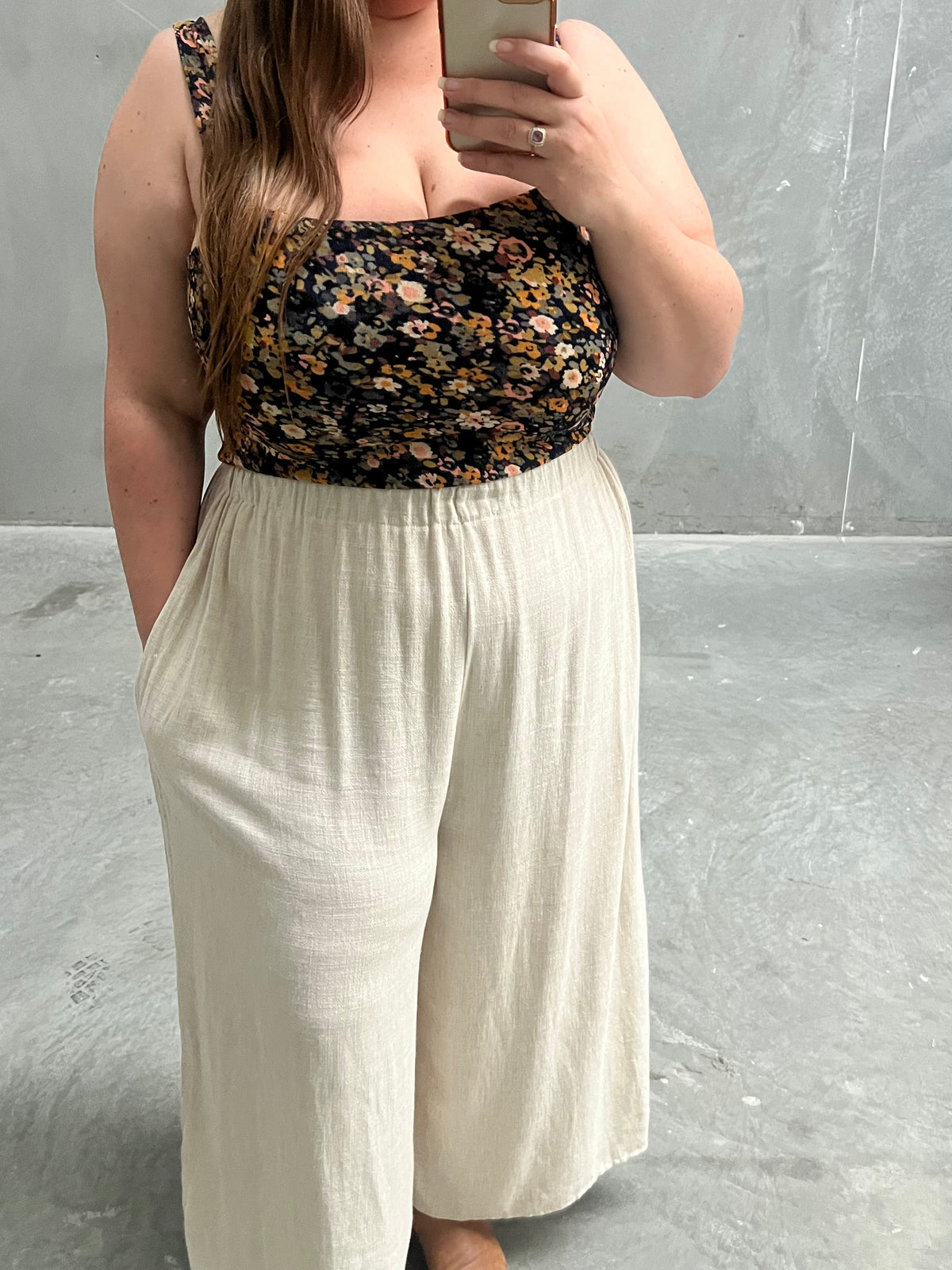 Mirror selfie of model in navy floral Aubrey Top with cream wide-leg pants