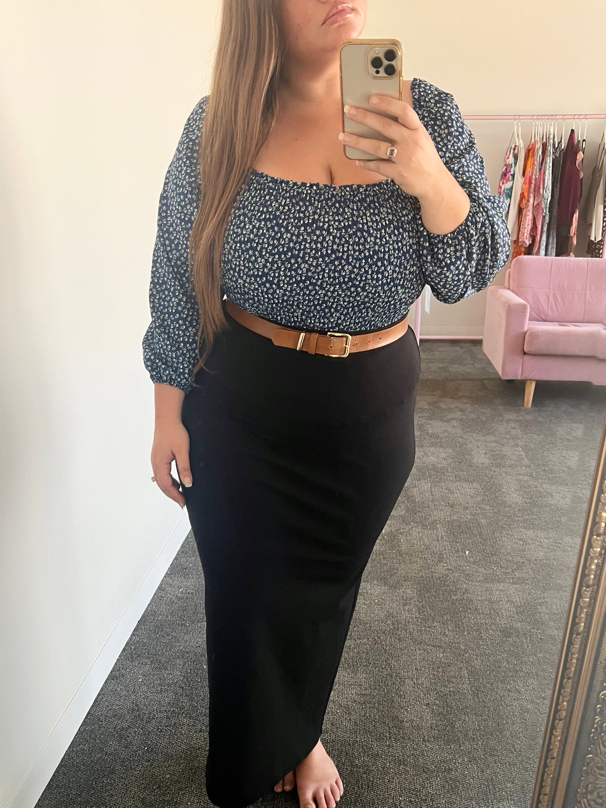 Model in black Audrey Maxi Skirt styled with a navy floral blouse and tan belt, mirror selfie
